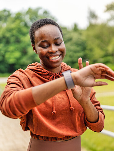 Woman smiling and looking at fitness watch