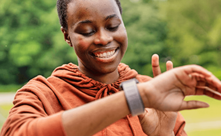 Woman smiling and looking at fitness watch