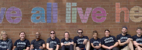 People standing in front of a brick wall