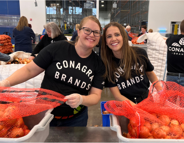 Employees holding produce
